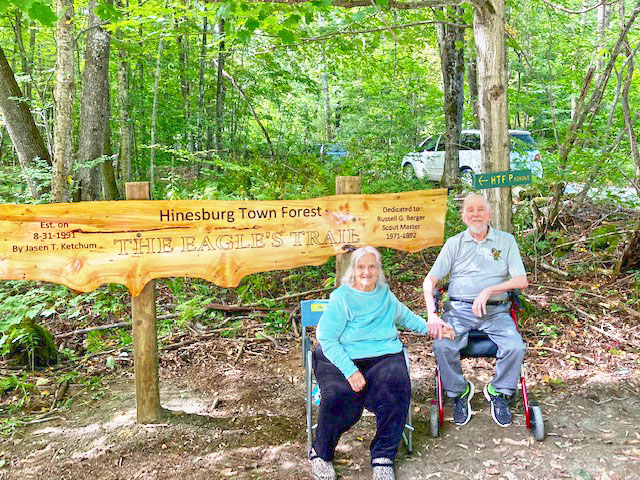 Russell Berger and his wife Nancy Berger in front of the newly replaced Eagles Trail sign at the Town Forest.