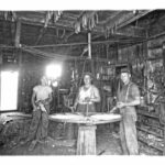 J.P., center, and Vic, left, repairing wagon wheel 1939